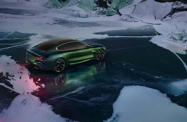 Green BMW m8 standing on frozen water in snow in winter