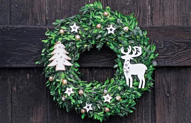 Groene kerstkrans met houten muurachtergrond