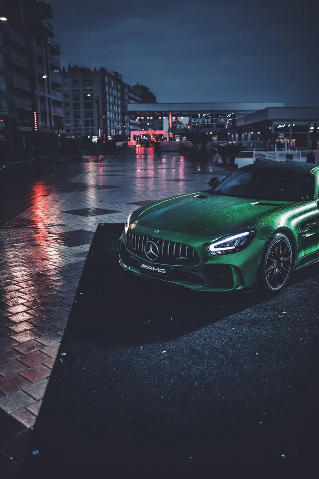 Mercedes verde en la noche en la calle lluviosa