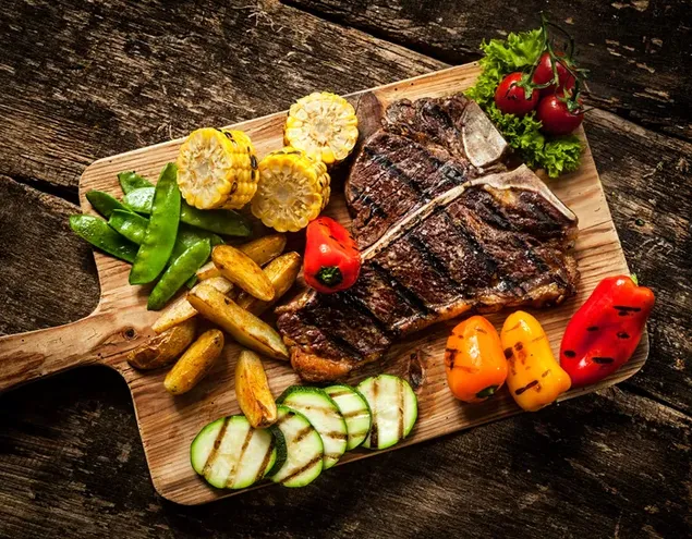 Zrezek na žaru s koruzo, krompirjem, papriko, grahom, paradižnikom in kumaro v pladnju 4K ozadje