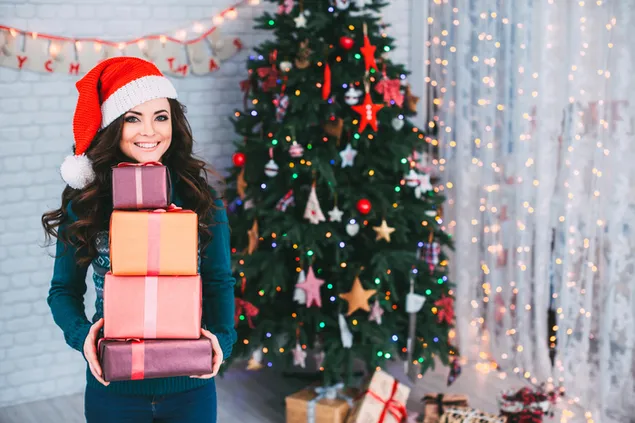 Gadis bahagia dan tersenyum dengan banyak hadiah Natal