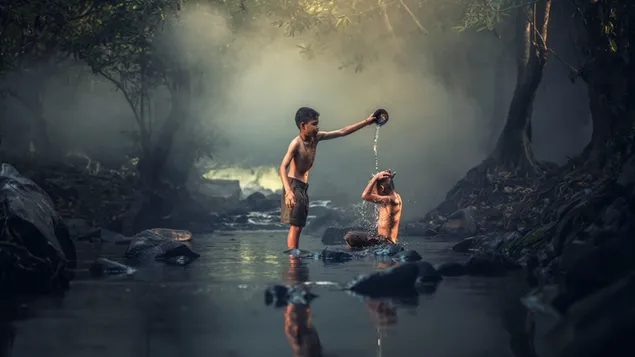 Среќни азиски деца кои се забавуваат на поток во маглива шума 4K тапет