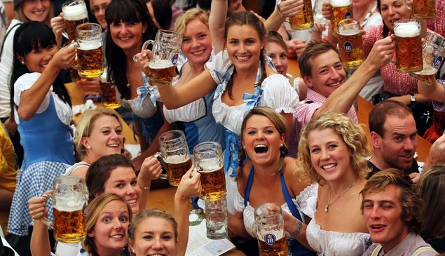 ドイツのオクトーバーフェストからビールを飲む群衆の幸せなポーズ