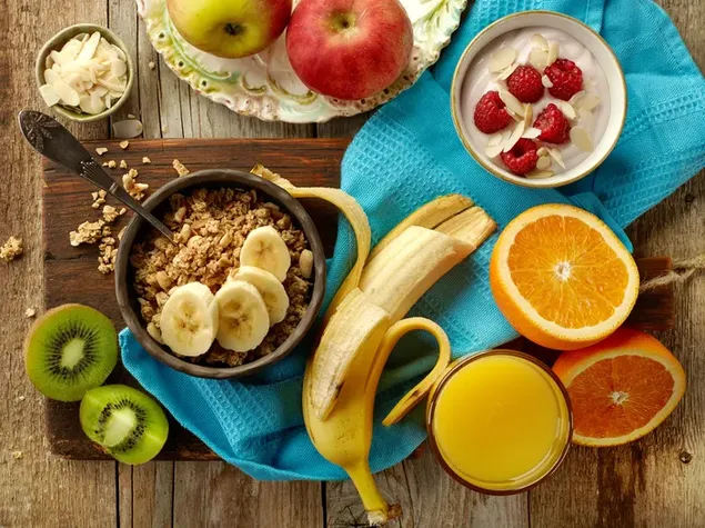 Sarapan sehat sereal dan buah-buahan dengan jus di meja kayu