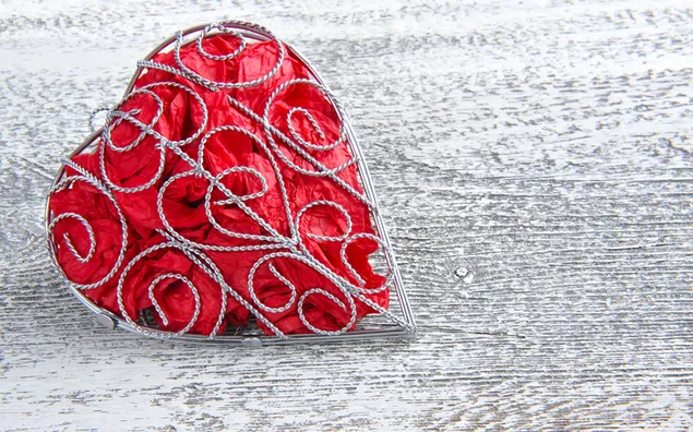 gabbia ricamata a forma di cuore su fondo grigio scarica