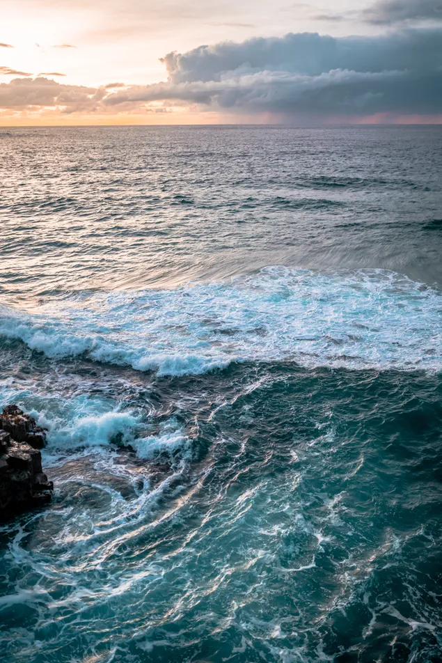 黒い岩層に衝突する海の波