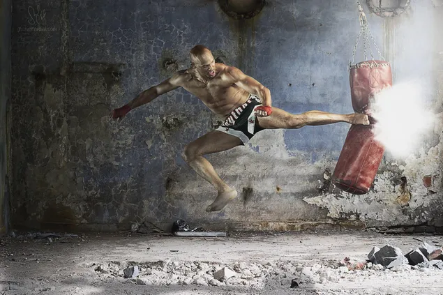 Hombre trabajando con saco de boxeo en entrenamiento de muay thai