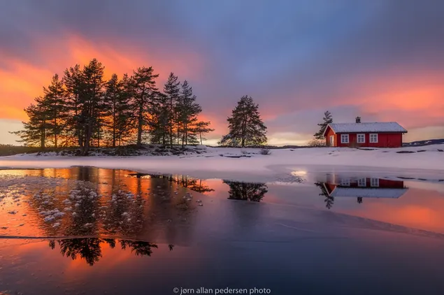 Reflexión de la casa y la naturaleza en el lago de invierno