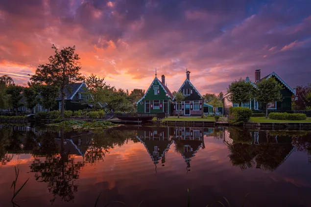 Houses reflected in the lake at sunset