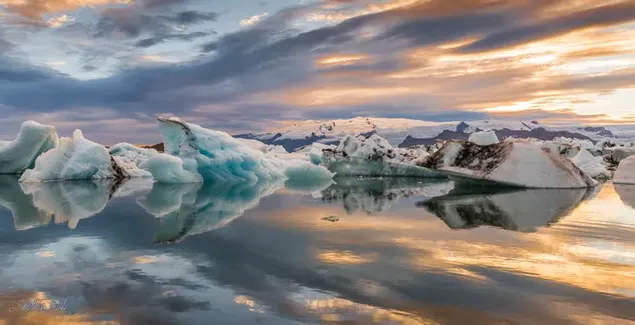 Icebergs y nubes del cielo reflejadas en el agua al atardecer descargar