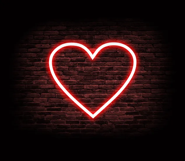 segno di cuore illuminato sul muro di mattoni scarica