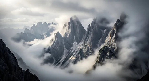 muat turun puncak gunung bergerigi muncul secara mendadak melalui lautan kabus dan awan yang berpusar, mencipta landskap alpine yang menakjubkan dan misteri.