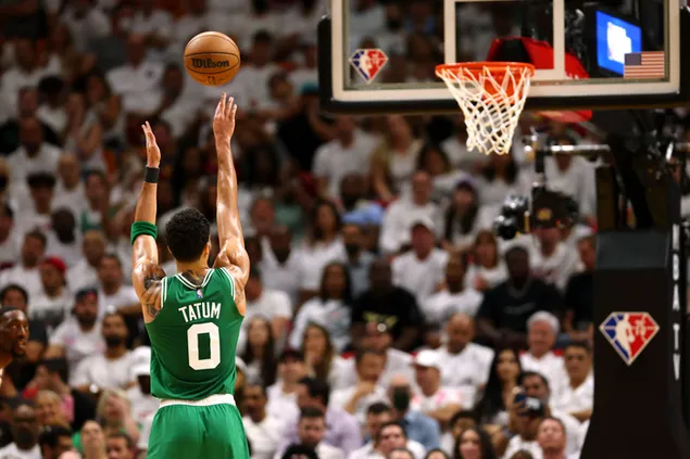 Jayson Tatum de los Boston Celtics lanzando una pelota al aro de baloncesto entre la multitud en el estadio descargar