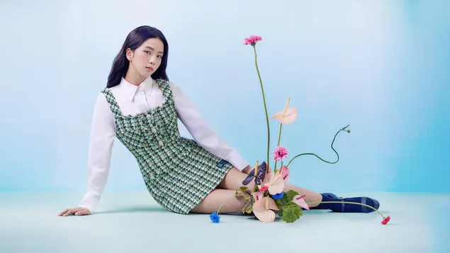 Páipéar balla Jisoo agus a bláth ildaite ina suí i léine bán, gúna mionphrionta agus bróga dubha ar chúlra gorm agus bán éadrom2K