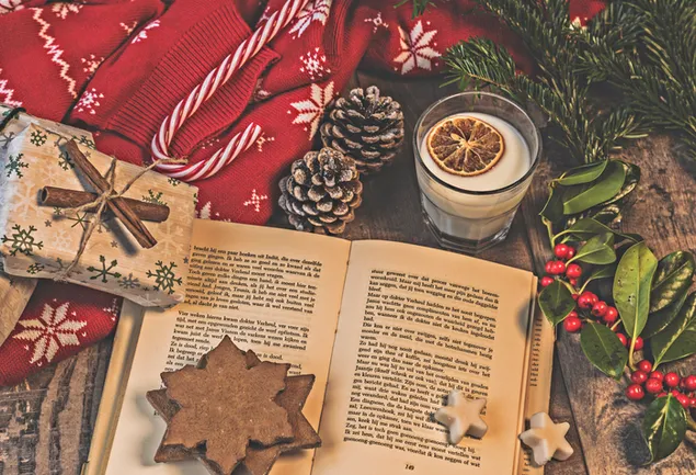 開いた本、クッキー、クリスマスの飾りとミルク