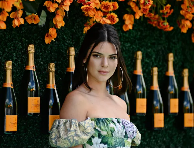 Kendall Jenner con flores naranjas y fondo vino