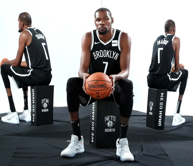Kevin durant sentado con una pelota de baloncesto en las manos y su reflejo en los espejos detrás de su descargar