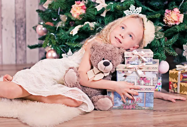 Klein meisje knuffelt haar cadeaus met Kerstmis