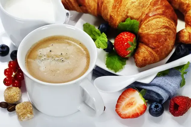 クロワッサン、ベリー、コーヒー、ミルクを使ったアロマティックな朝食