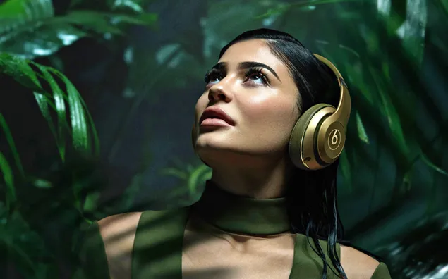 Kylie Jenner wearing a headset with plants background