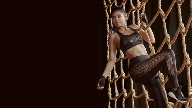 Kylie Jenner con puma escalando una cuerda 8K fondo de pantalla