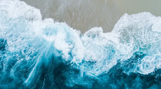 La espuma de las olas formadas por las aguas del océano golpeando la orilla
