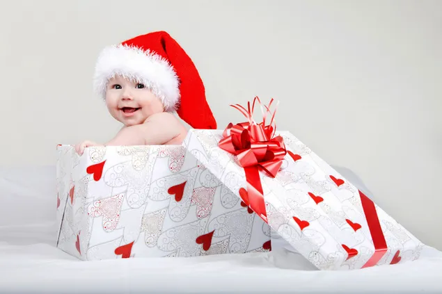 Lächelndes süßes Baby in der Geschenkbox und das beste Weihnachten