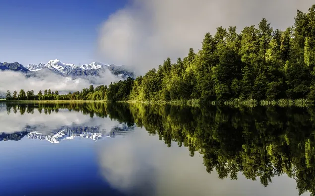 Lago Matheson con montañas nubladas y bosques reflejados en el lago 2K fondo de pantalla