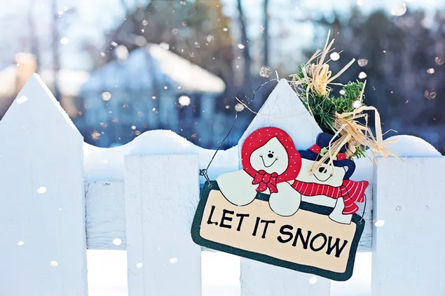 Let It Snow-Schild in einem schneeweißen Zaun