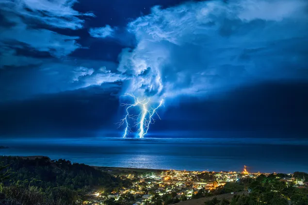 Blitz über dem Meer hinter den Bürgerhäusern und Bergen 2K Hintergrundbild