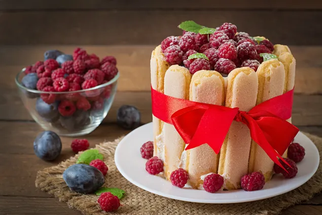 Lindo diseño de mini-pastel de frambuesa y arándano con lazo rojo