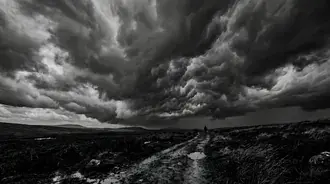 lone figure under stormy skies: a dramatic black & white landscape download