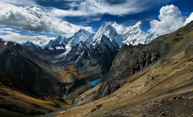 Prächtiges Gemälde der verschneiten Anden mit ihrer Wolkenlandschaft inmitten der Steppe 2K Hintergrundbild