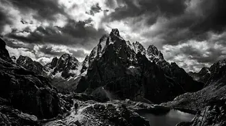 majestic mountain trek: dramatic peaks, serene lake, and hiker