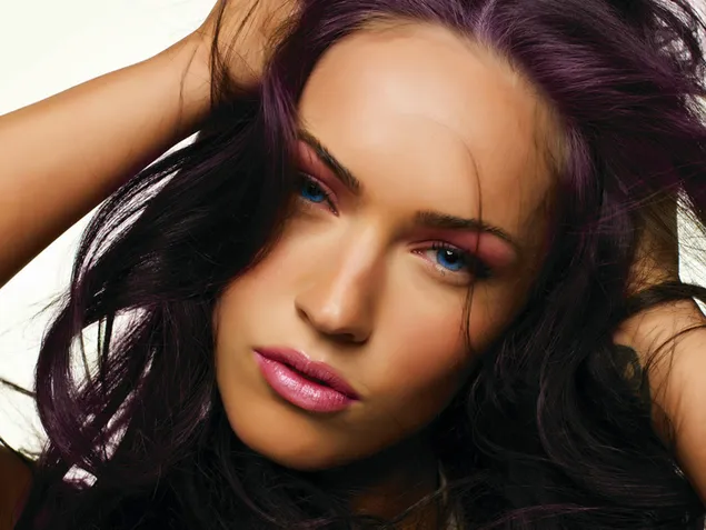 Megan Fox posing uniquely with her blue eyes and well-groomed hair download