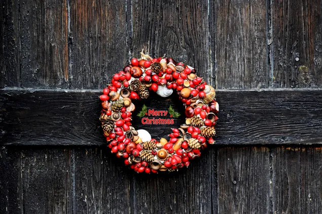 Flor de muérdago y corona navideña de piña con fondo de pared de madera
