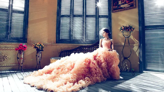 Modell im Hochzeitskleid zu Hause dekoriert mit Holzfenstern und Vasen mit Blumen auf Holzboden