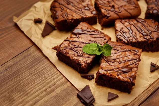 Brownies umede stropite cu sirop de ciocolată cu batoane de ciocolată rupte în lateral 4K imagine de fundal