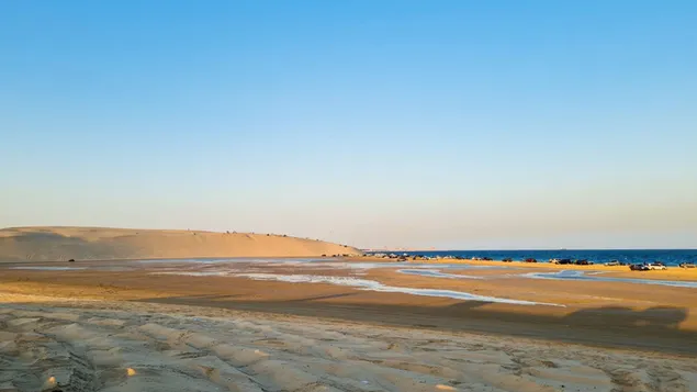 Montaña de arena en el desierto y mar azul
