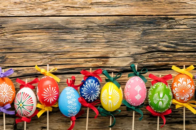 Večbarvno velikonočno poslikano jajce z umetniškim dizajnom s pisanimi trakovi na stari leseni deski 4K ozadje