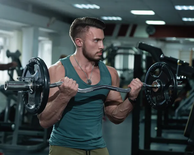 Muskuløs mand træner med at løfte vægte med grøn skjorte download