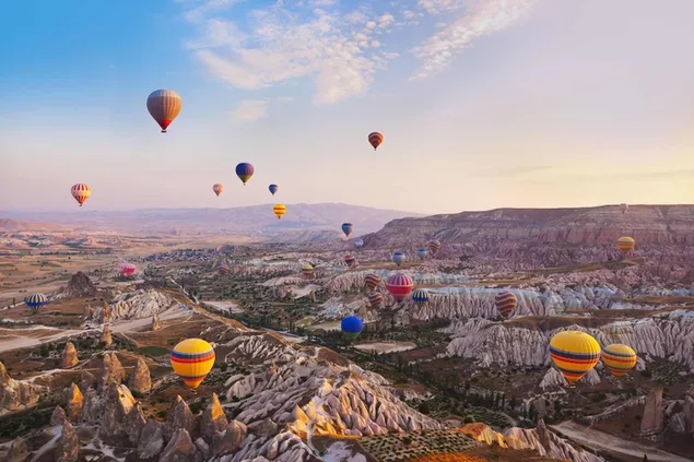 Природні споруди та повітряні кулі літають рано вранці в Невшехірі, Туреччина завантажити