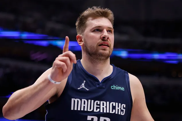 El jugador de baloncesto de la liga de la NBA, Loka Doncic, con un jersey azul y blanco, muestra la mano en Stadta