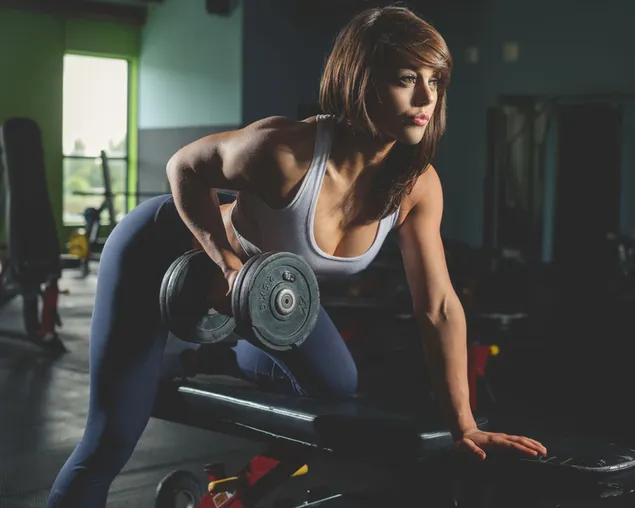 Người đẹp đang tập tạ với tạ trong phòng tập thể dục tải xuống