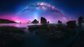 Visão noturna de silhuetas de água e montanha refletidas na aurora boreal 4K papel de parede