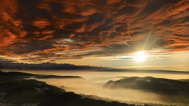 濃い雲の後ろで、日光が霧の中で地球のシルエットを描きます。