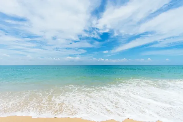 Oceaangolven die het strand raken bij helder bewolkt weer 4K achtergrond