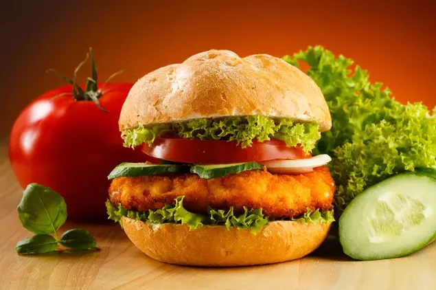 Satu burger ayam besar dengan tomat, mentimun, dan selada