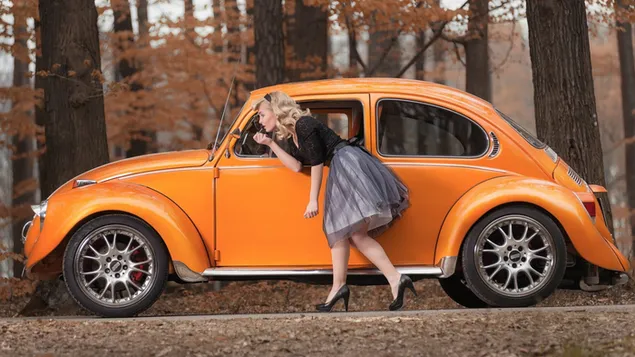Oranje volkswagen kever en damesmodel