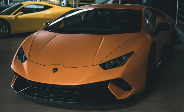 Oranje Lamborghini Huracan in de buurt van gele sportwagen
